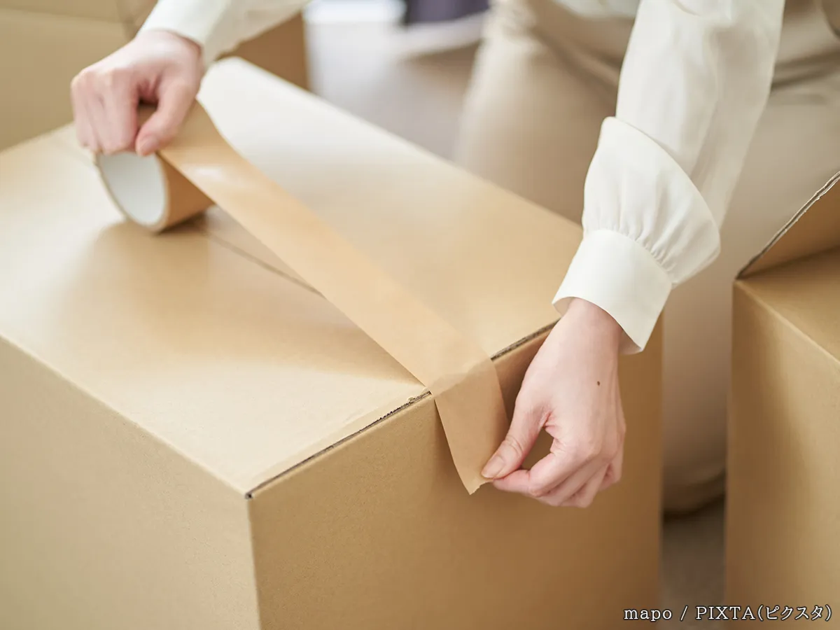 粘着テープをダンボールに貼る写真