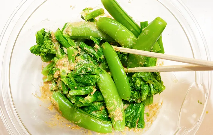 菜の花とスナップエンドウを加えて混ぜている画像（撮影：エニママ）