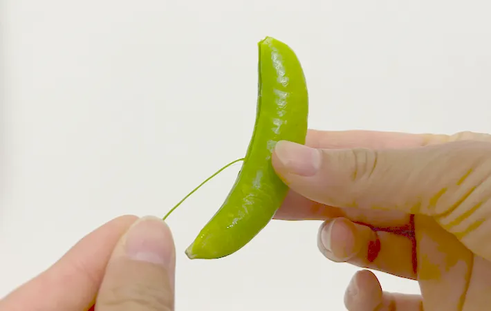 スナップエンドウの筋を取っている画像（撮影：エニママ）