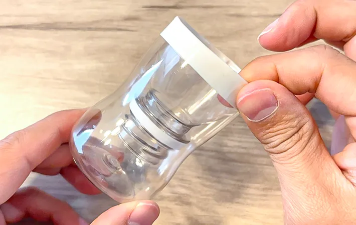 『R-1』の容器にテープを貼りつけている写真（撮影：キジカク）