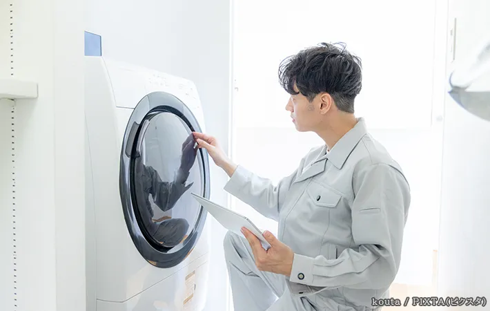 洗濯機を確認する人の写真