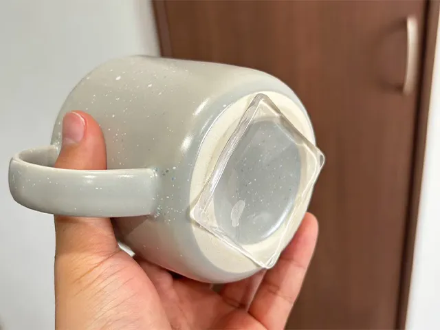 耐震マットをコップに貼って、持ち上げる場面（撮影：キジカク）