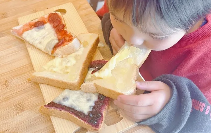 『ジャムチーズトースト』を食べる子供の写真（撮影：キジカク）