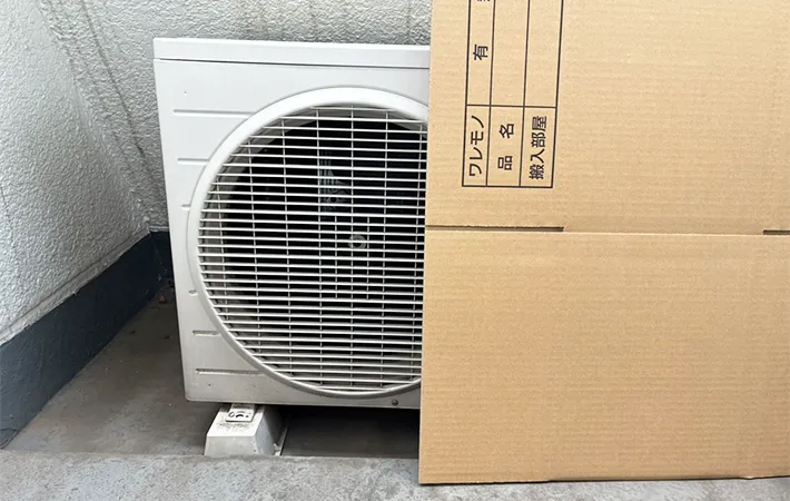 ダンボールを立てかけた室外機の写真（撮影：grapeライフハック編集部）