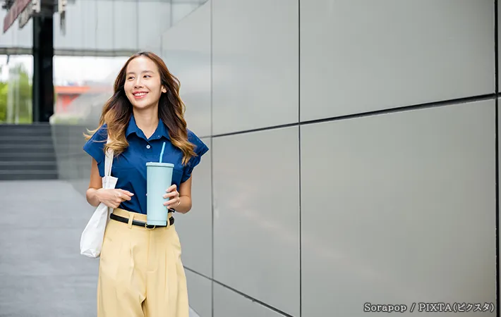 タンブラーを持つ女性の写真