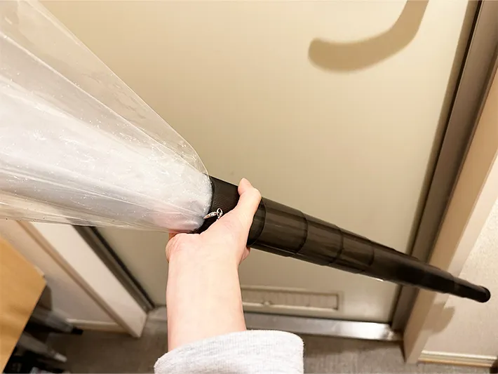 『伸縮傘カバー』に長傘を入れている画像（撮影：grapeライフハック編集部）