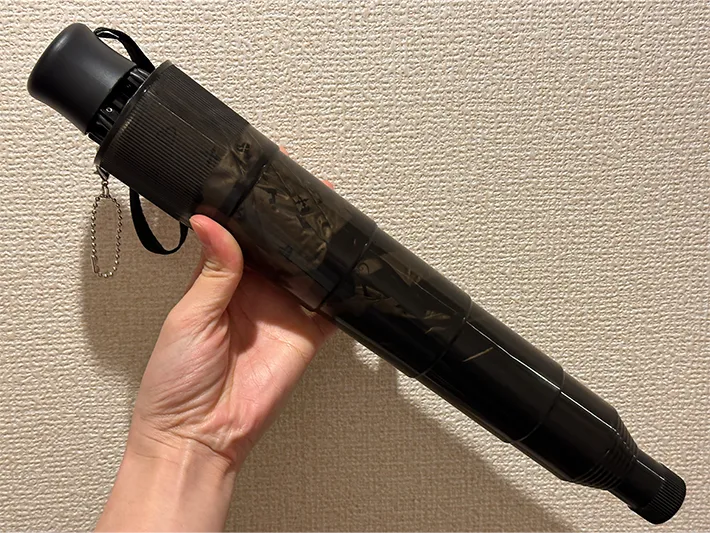 『伸縮傘カバー』に折りたたみ傘を入れている画像（撮影：grapeライフハック編集部）