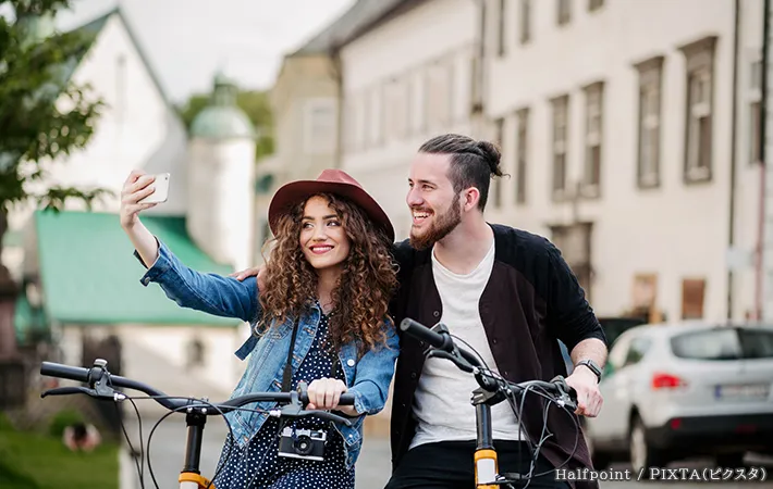仲よく並んで自転車に乗る女性の写真