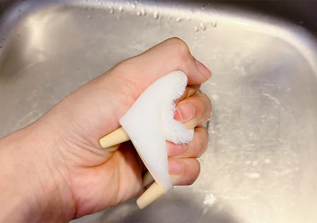 ダイソーの『立つおそうじキューブ』を手で強くにぎった場面（撮影：grapeライフハック編集部）