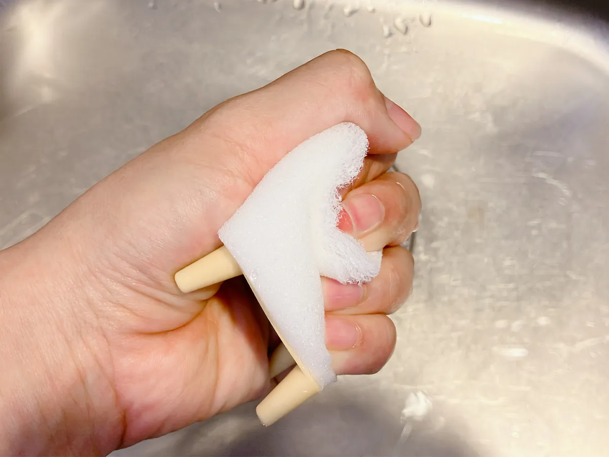 ダイソーの『立つおそうじキューブ』を手で強くにぎった場面(撮影:grapeライフハック編集部)