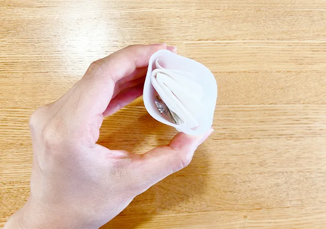 『携帯便利 薄型シリコーンコップ』の中に物を入れて、手に持って広げた場面（撮影：grapeライフハック編集部）