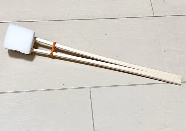 割り箸、輪ゴム、スポンジを合体させたものを床に置いた場面（撮影：grape編集部）