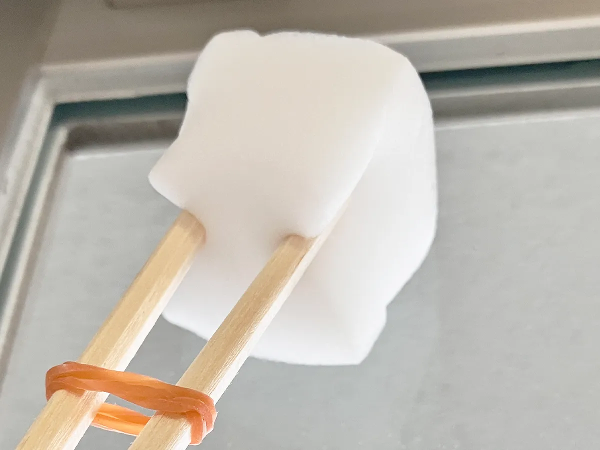 割り箸、輪ゴム、スポンジを合体させたアイテムで窓掃除をする場面（撮影：grape編集部）