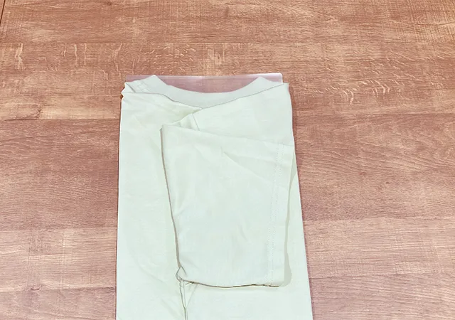 Tシャツの上にクリアファイルを置き、袖を折った場面（撮影：grapeライフハック編集部）