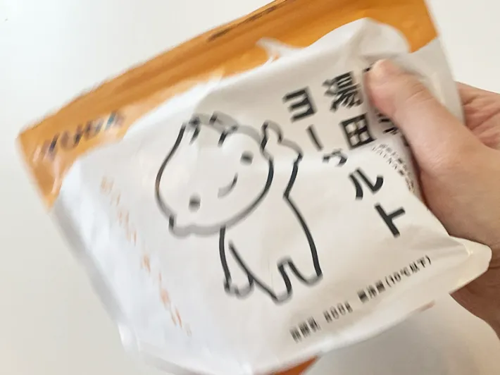 牛乳を入れたプレミアム湯田ヨーグルトを振る写真（撮影：grapeフード編集部）