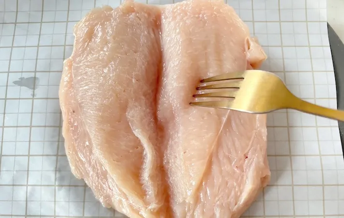 鶏むね肉にフォークで穴を開けている画像（撮影：エニママ）