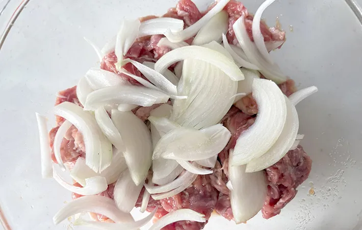 豚こま肉の上にタマネギを広げた画像（撮影：エニママ）