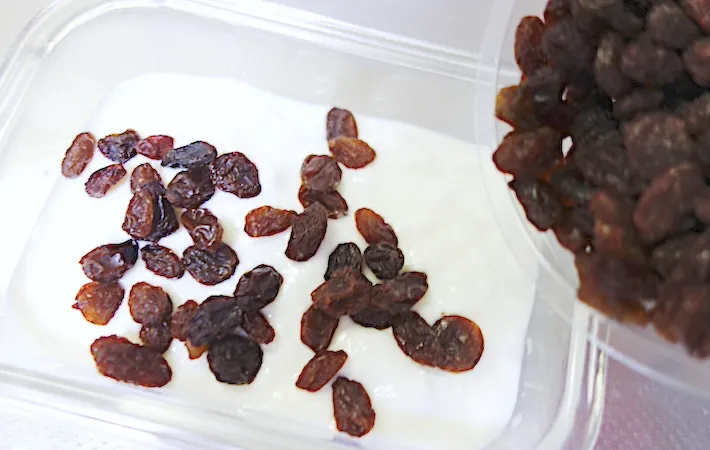 ヨーグルトとレーズンを保存容器に入れている画像（撮影：エニママ）