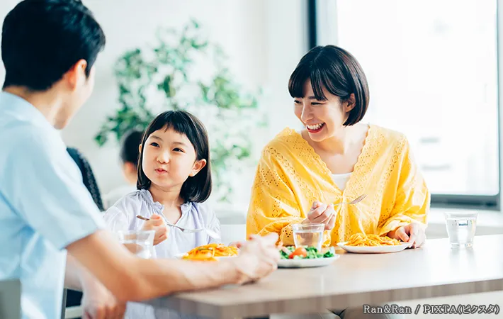 楽しそうに食事をする親子の写真