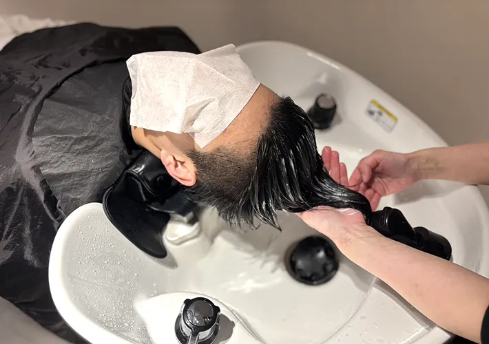 コンディショナーを髪につけている写真