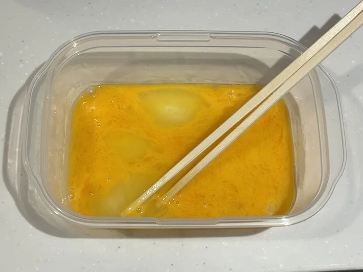 溶いた卵を入れたタッパーの写真（撮影：grapeフード編集部）