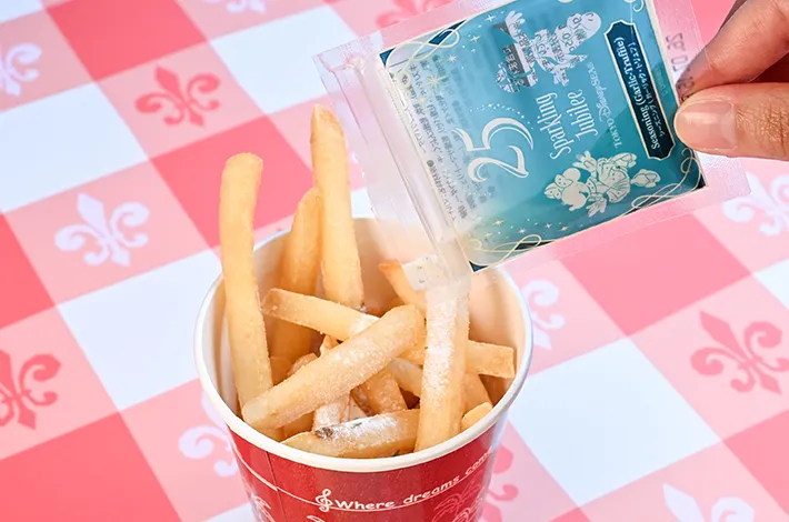 シーズニング（ガーリック・トリュフ）をポテトにかける写真（撮影：grapeフード編集部）