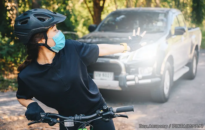 自転車に乗る女性と車の写真
