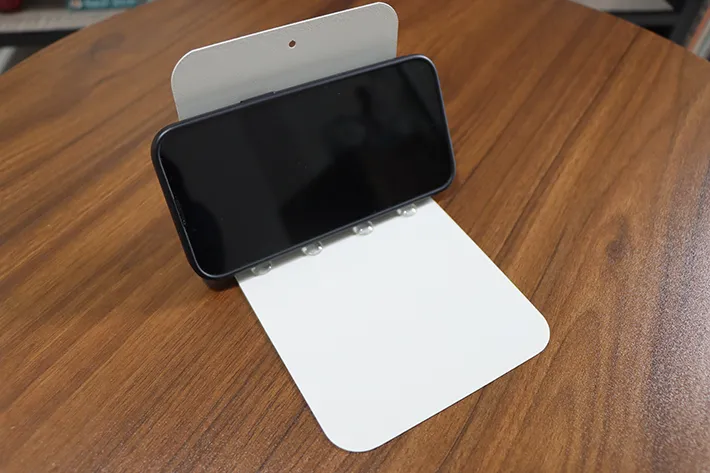 クッションゴムをつけたブックエンドに立てかけるスマホの写真（撮影：grapeライフハック編集部）