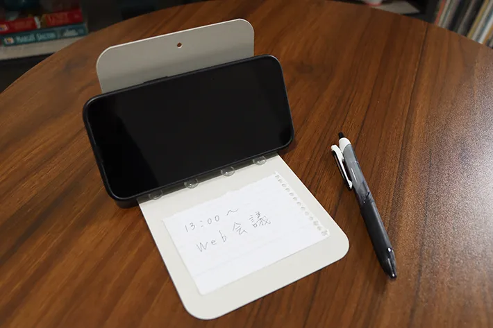 クッションゴムをつけたブックエンドに立てかけるスマホとメモの写真（撮影：grapeライフハック編集部）