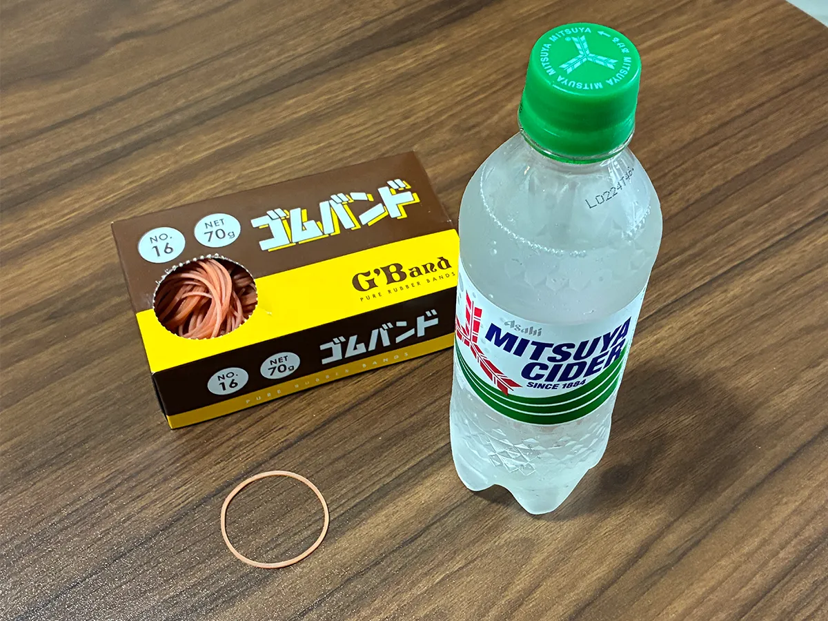 机に置かれた炭酸飲料と輪ゴムの写真（撮影：grapeライフハック編集部）