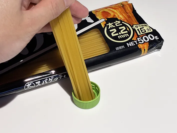 パスタの乾麺を入れたペットボトルのキャップの写真（撮影：grapeライフハック編集部）