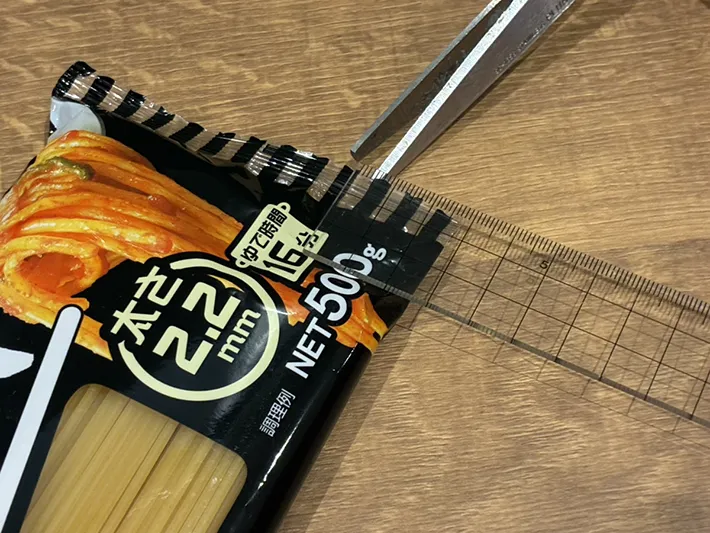 パスタの袋に切れ込みを入れようとする場面の写真（撮影：grapeライフハック編集部）