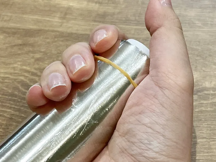 輪ゴムを巻いたラップを握った写真