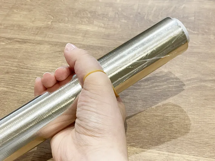 手に輪ゴムを引っかけてラップをひねる写真