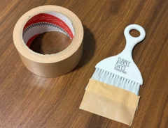 机に置かれたミニほうきとガムテープの写真（撮影：grapeライフハック編集部）