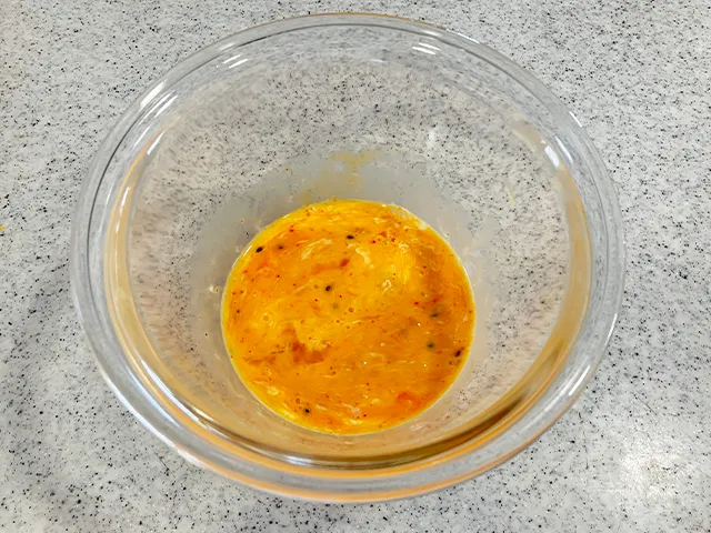 マヨネーズ、ラー油、七味唐辛子を入れて、卵を溶いた場面（撮影：grapeフード編集部）