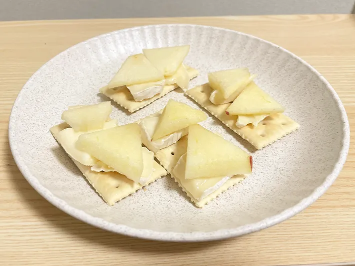 クラッカーにチーズとリンゴを重ねる写真（撮影：grape芸能編集部）