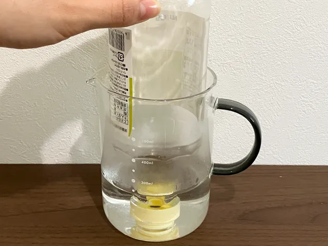 瓶を逆さまにしてお湯に浸けた場面（撮影：grapeライフハック編集部）