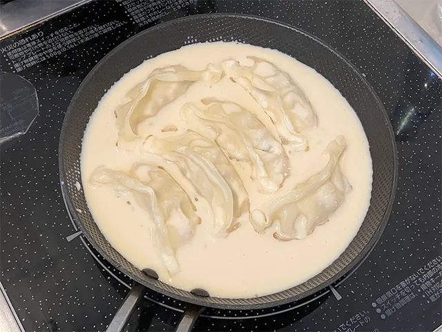 餃子をフライパンに並べ、豆乳を注いだた場面（撮影：grapeフード編集部）