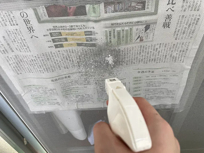網戸にクリーナーを噴射する写真（撮影：grapeライフハック編集部）