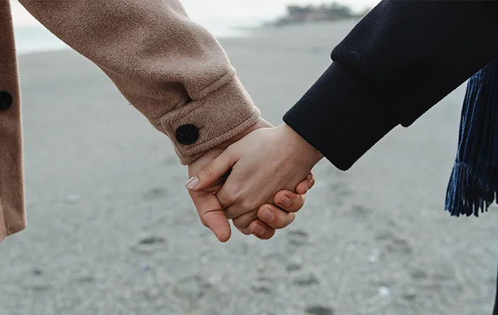 手をつなぐカップルの写真