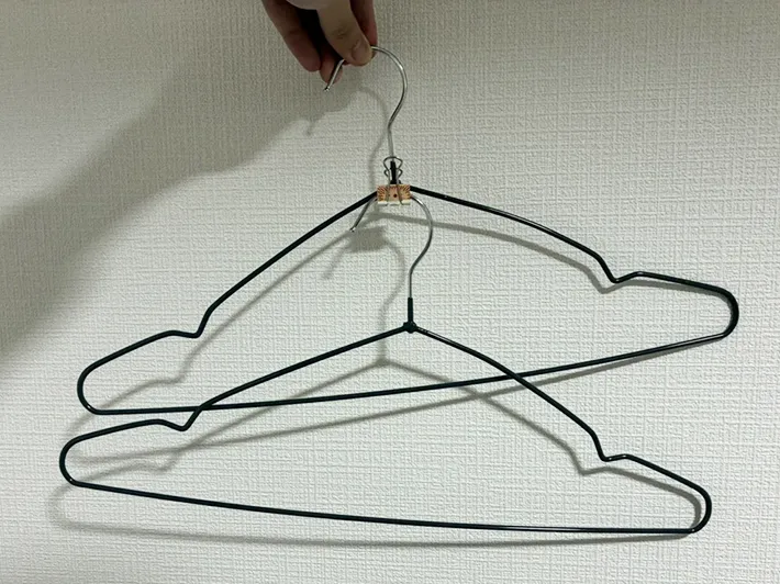 指でつかんだ2本のハンガーの写真（撮影：grapeライフハック編集部）
