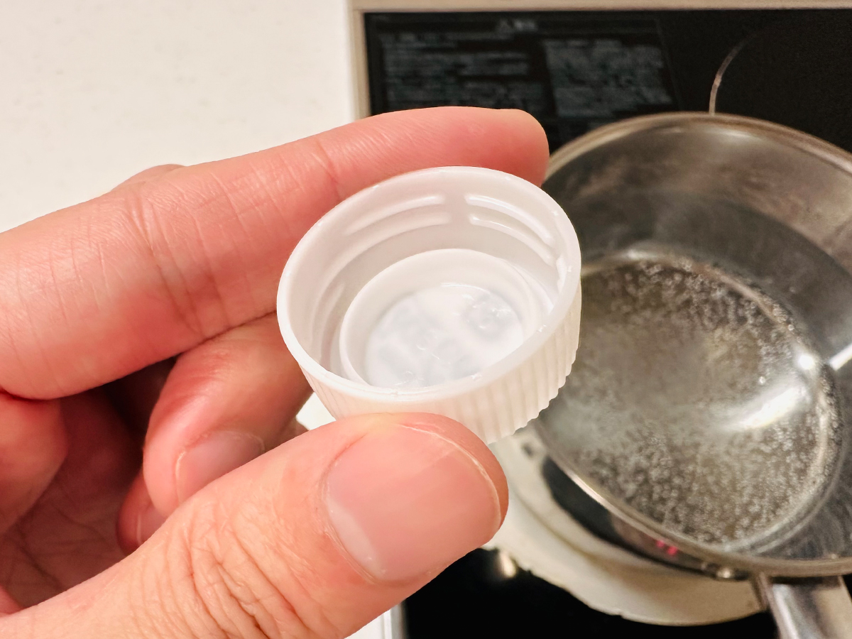 ペットボトルキャップを指で挟んで持っている写真