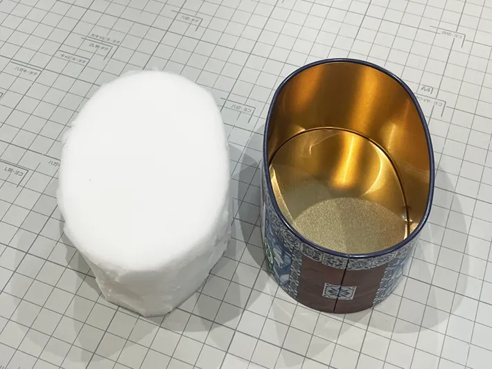 お菓子缶の形に合わせてメラミンスポンジを切った写真（撮影：grapeライフハック編集部）