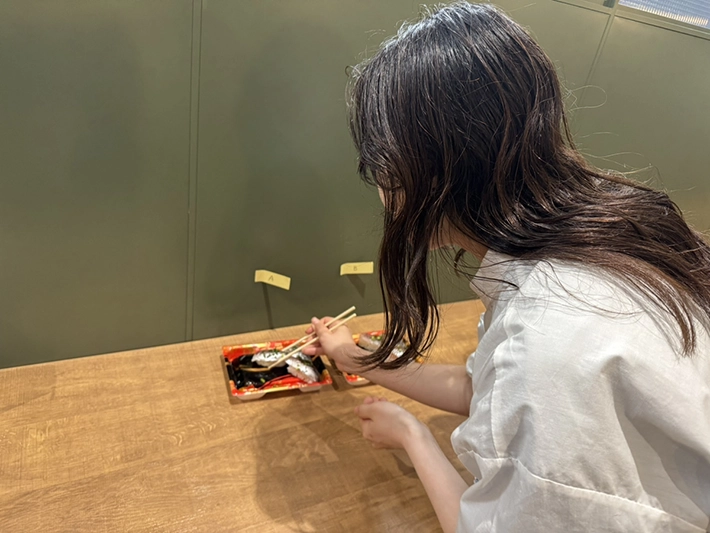 寿司パックのライフハックを検証する社員の写真（撮影：grapeフード編集部）