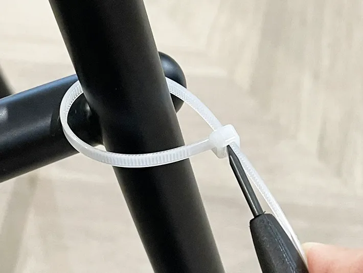 結束バンドにマイナスドライバーを挿してバンドをゆるめる写真（撮影：grapeライフハック編集部）