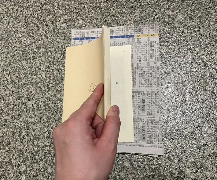 新聞紙を本に挟む写真（撮影：grapeライフハック編集部）