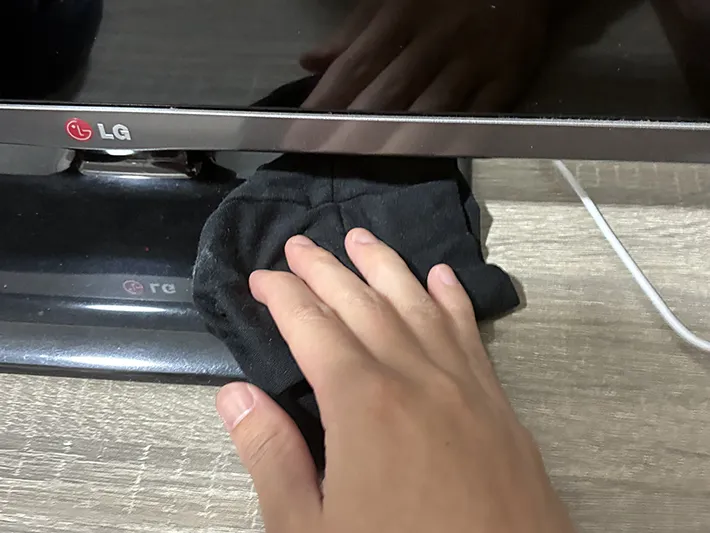 ヒートテックの布でテレビを拭き取る場面の写真（撮影：grapeライフハック編集部）