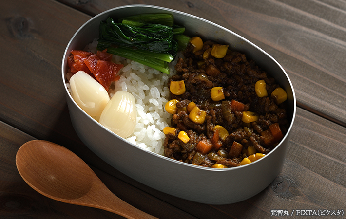 お弁当に詰めたカレーを食べようとしている写真