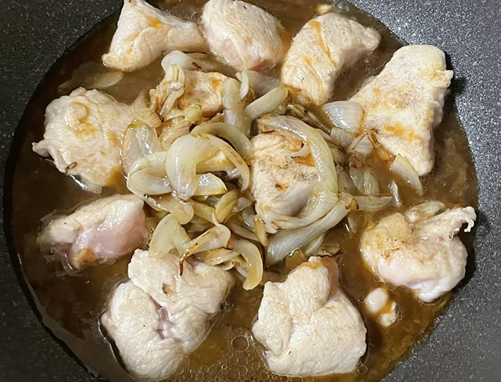 鶏肉、タマネギをタレで煮込む写真（撮影：grapeフード編集部）